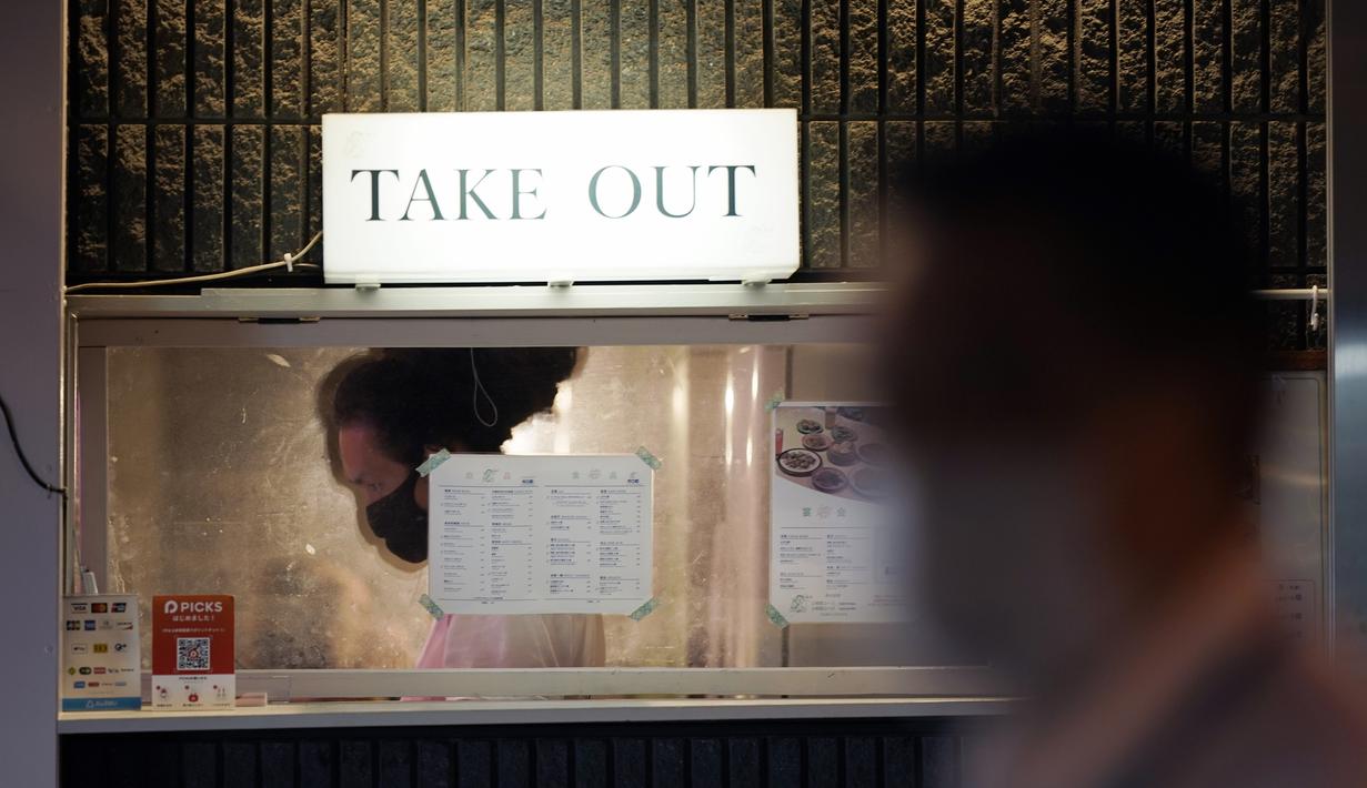 Seorang karyawan restoran yang memakai masker untuk membantu mencegah penyebaran virus corona menyiapkan makanan di Tokyo, Kamis (10/9/2020). Ibukota Jepang mengonfirmasi lebih dari 270 kasus virus korona pada hari Kamis. (AP Photo / Eugene Hoshiko)