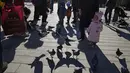 Seorang anak melihat ke dekat merpati di sebuah taman di Beijing, China (13/1/2022). Partai Komunis yang berkuasa khawatir fakta ini bisa menghalangi ambisi mereka untuk meningkatkan kekayaan nasional dan pengaruh global. (