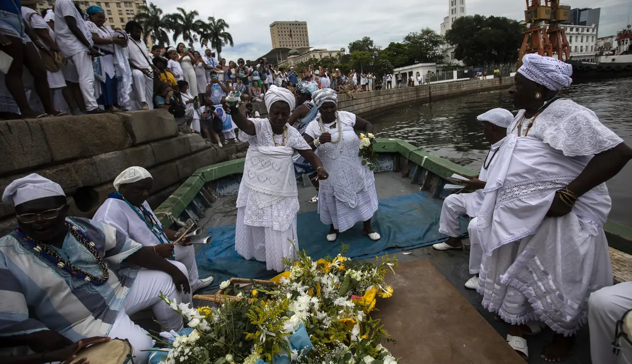 Para pemuja bernyanyi dan menari saat mereka mempersiapkan persembahan untuk dewi laut Yemanja selama perayaan tahunan dewa tersebut, yang diselenggarakan oleh "Sons of Gandhi", di Teluk Guanabara di Rio de Janeiro, Brasil, Kamis, 2 Februari 2023. (AP Photo/Bruna Prado)