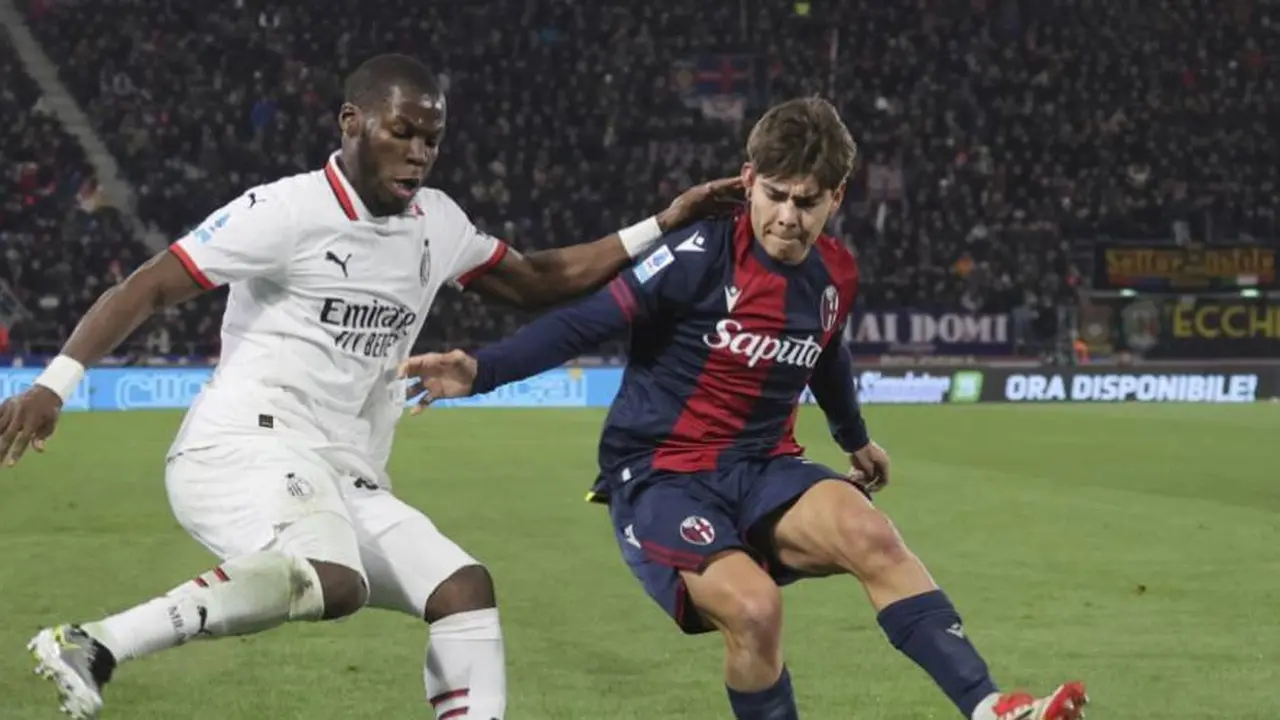 Yunus Musah berduel dengan Benjamin Dominguez dalam laga Bologna vs AC Milan di Serie A 2024/2025, Jumat (28/2/2025) dini hari WIB. (c) Michele Nucci/LaPresse via AP