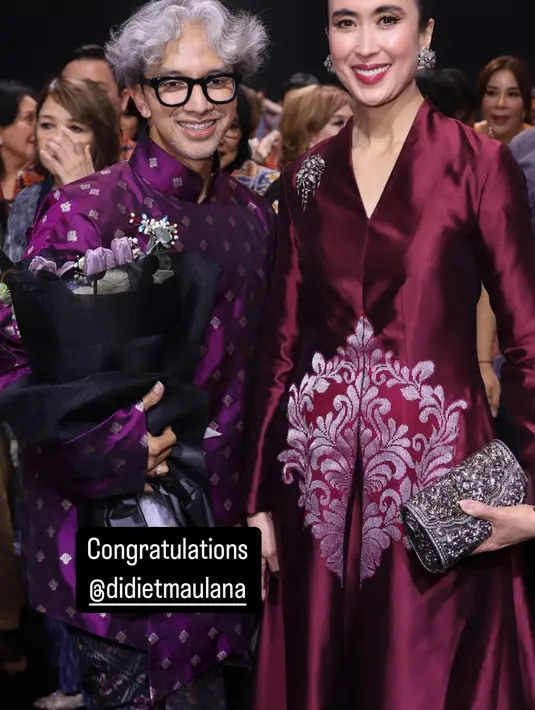 Lengkapi dress megahnya, Widi Wardhana jinjing clutch wastra warna silver dan anting bunga [@widi.wardhana]