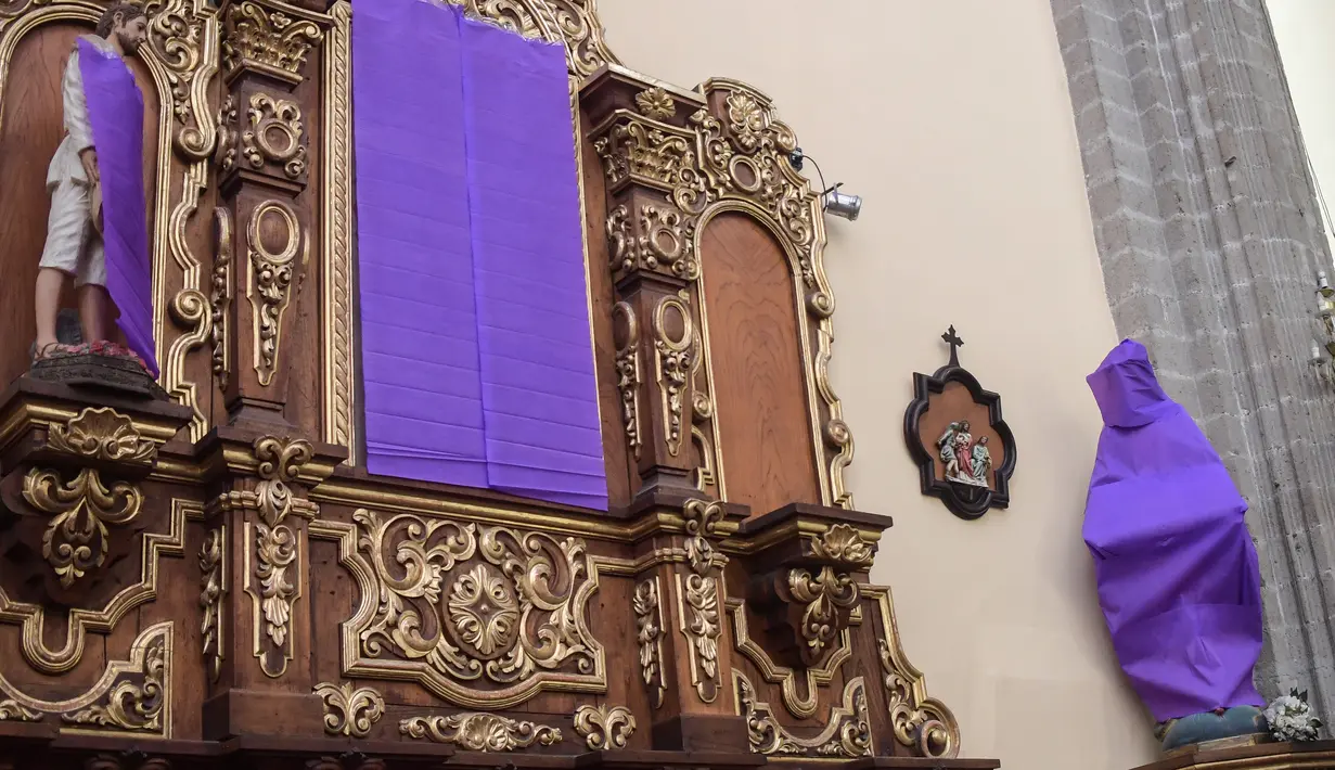 Pemandangan patung perempuan ditutupi dengan kain ungu di Gereja De los Santos Cosme y Damian di Mexico City, pada Rabu (4/3/2020). Penutupan patung tersebut sebagai bentuk protes terhadap kekerasan gender. (Photo by Pedro PARDO / AFP)