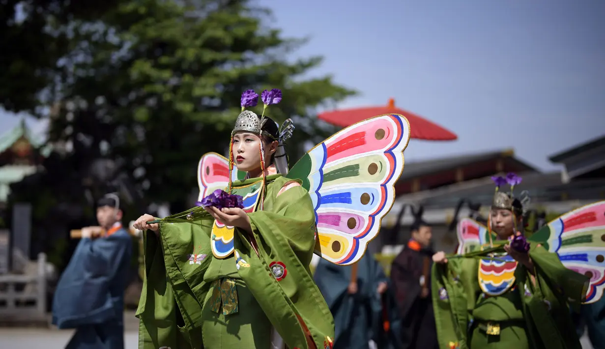 Pendeta Shinto muda yang disebut "miko" berpartisipasi dalam upacara upacara untuk festival dua tahunan yang disebut "Kanda Matsuri" di kuil Kanda di Tokyo (18/5/2022). Festival yang diadakan untuk kebahagiaan umat paroki kuil dan keselamatan Jepang ini pernah didukung oleh Keshogunan Tokugawa pada abad ke-17. (AP Photo/Eugene Hoshiko)