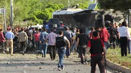 Petugas polisi berpakaian preman berdatangan ke lokasi ledakan bom mobil di kota Diyarbakir, Turki, Selasa (10/5). Ledakan menghantam kendaraan lapis baja polisi, setidaknya tiga korban tewas dan puluhan mengalami luka-luka (Ihlas News Agency via REUTERS)