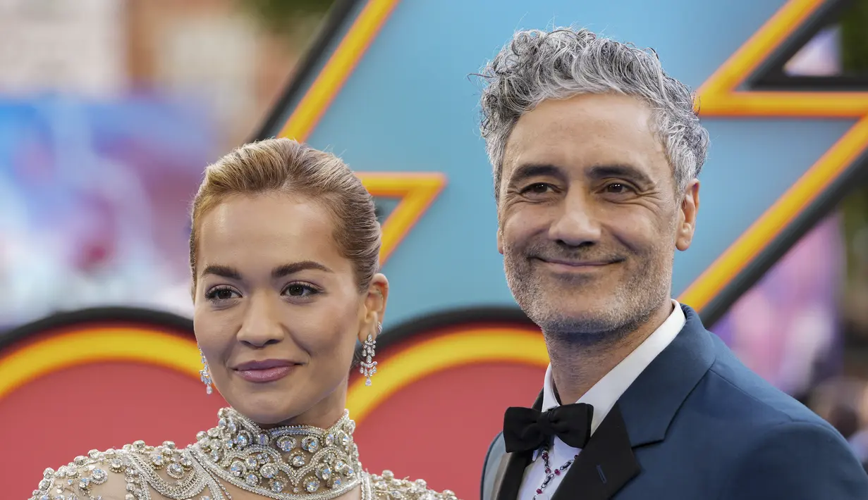 <p>Rita Ora bersama tunangannya sutradara Taika Waititi berpose saat tiba menghadiri pemutaran film 'Thor: Love and Thunder di London (5/7/2022). Tak ketinggalan sepasang anting berlian membuat penampilan Rita Ora makin berkilau. (AP Photo/Scott Garfitt)</p>