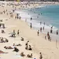 Orang-orang berkumpul di Pantai Bondi saat merayakan Natal di Sydney, Sabtu (25/12/2021). (AP Photo/Rick Rycroft)