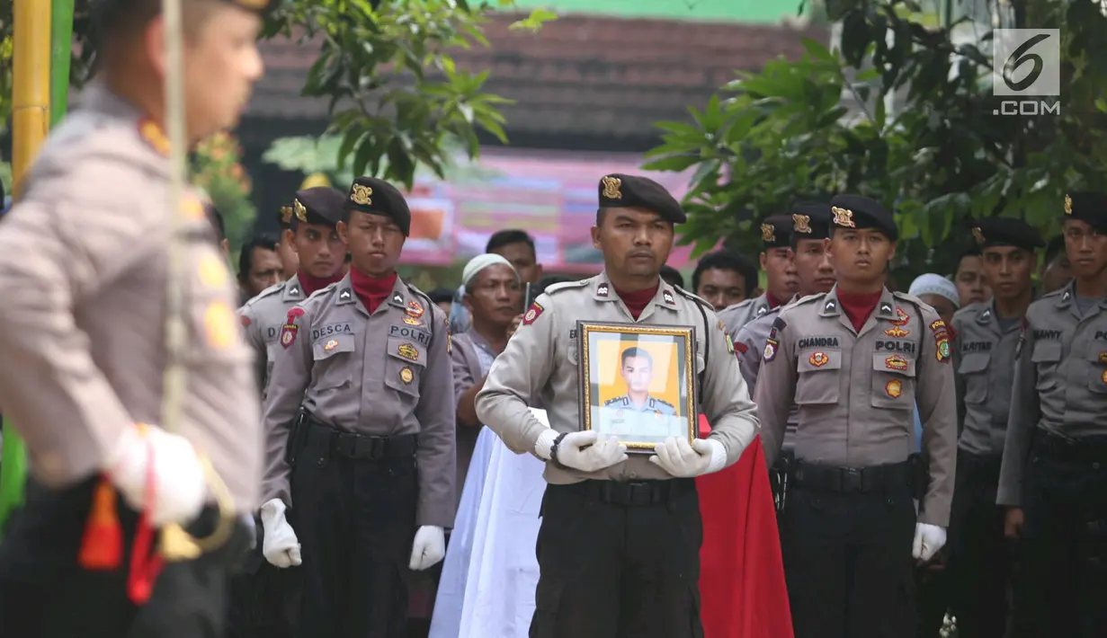 Personel kepolisian membawa foto jenazah Bripda Imam Gilang Adinata (24) yang gugur akibat bom Kampung Melayu, ketika upacara pelepasan di Menteng Dalam, Kamis (25/5). Briptu (anumerta) Imam akan dimakamkan di Klaten, Jateng. (Liputan6.com/Angga Yuniar)