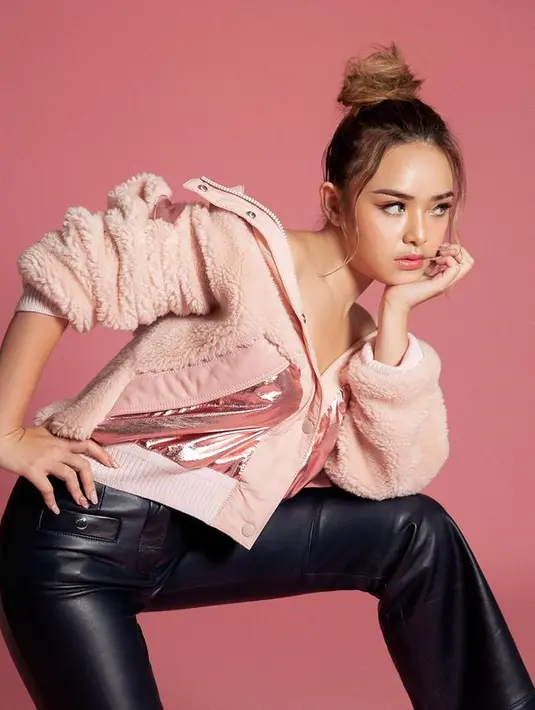 Amanda Manopo tampil girly dengan menata rambutnya bergaya up bun. Kesan girly semakin dipertegas dengan outfit pink dan black leather pants. (instagram/amandamanopo)