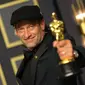 Aktor AS Troy Kotsur berpose dengan Piala Oscar di ruang pers Academy Award ke-94 di Dolby Theatre, Hollywood, Minggu (27/3/2022). Troy Kotsur memenangkan piala Oscar dalam kategori pendukung terbaik untuk perannya sebagai seorang nelayan dan ayah dalam film CODA. (Mike Coppola/Getty Images/AFP)