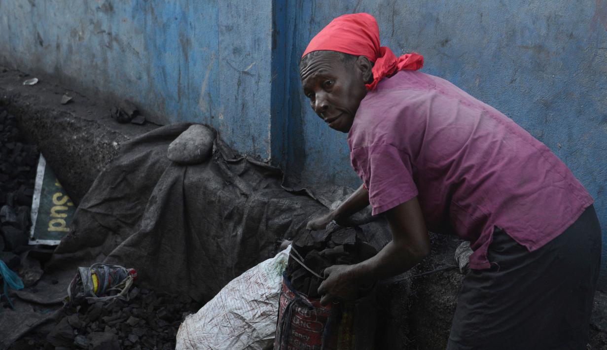 Seorang wanita mengumpulkan arang di depot yang akan dijualnya di pasar lokal, di Les Cayes, Haiti, (25/1). Peraturan tersebut untuk melindungi zona pemotongan kayu. (AP/David McFadden)