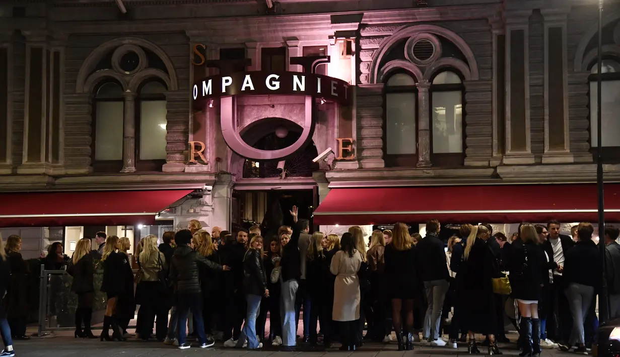 Orang-orang mengantre di luar klub malam untuk merayakan berakhirnya pembatasan selama pandemi Covid-19 di Stureplan di pusat Stockholm, Swedia, Rabu (29/9/2021). (Pontus Lundahl/TT via AP)