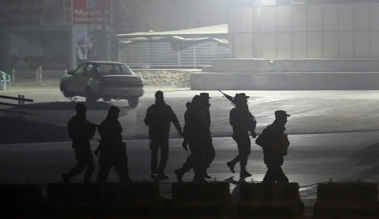 Pasukan keamanan berjalan menuju Hotel Intercontinental setelah serangan mematikan di Kabul, Afghanistan, Sabtu (20/1). Kelompok bersenjata membunuh setidaknya lima orang dan melukai delapan lainnya. (AP Photo/Massoud Hossaini)