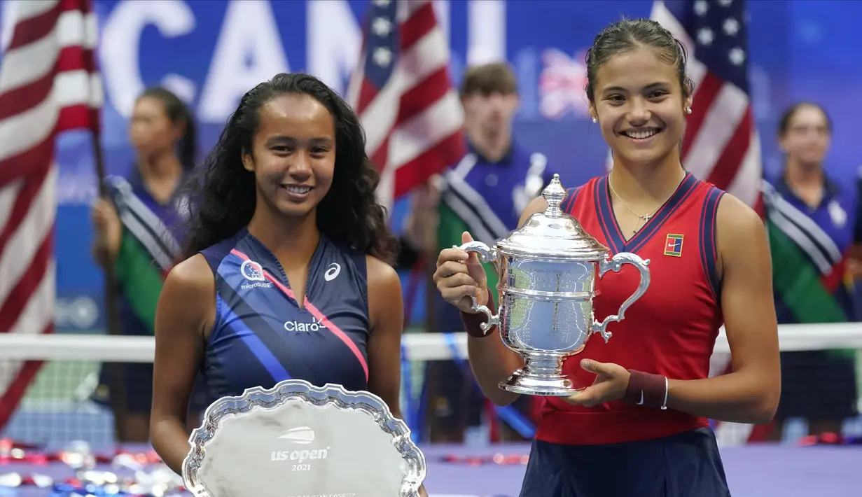 Petenis Inggris, Emma Raducanu (kanan) dan Leylah Fernandez dari Kanada berfoto dengan trofi usai pertandingan final tunggal putri US Open 2021 di Arthur Ashe Stadium, New York, Minggu (12/9/2021). Raducanu juara di usia yang masih muda, 18 tahun. (AP Photo/Seth Wenig)