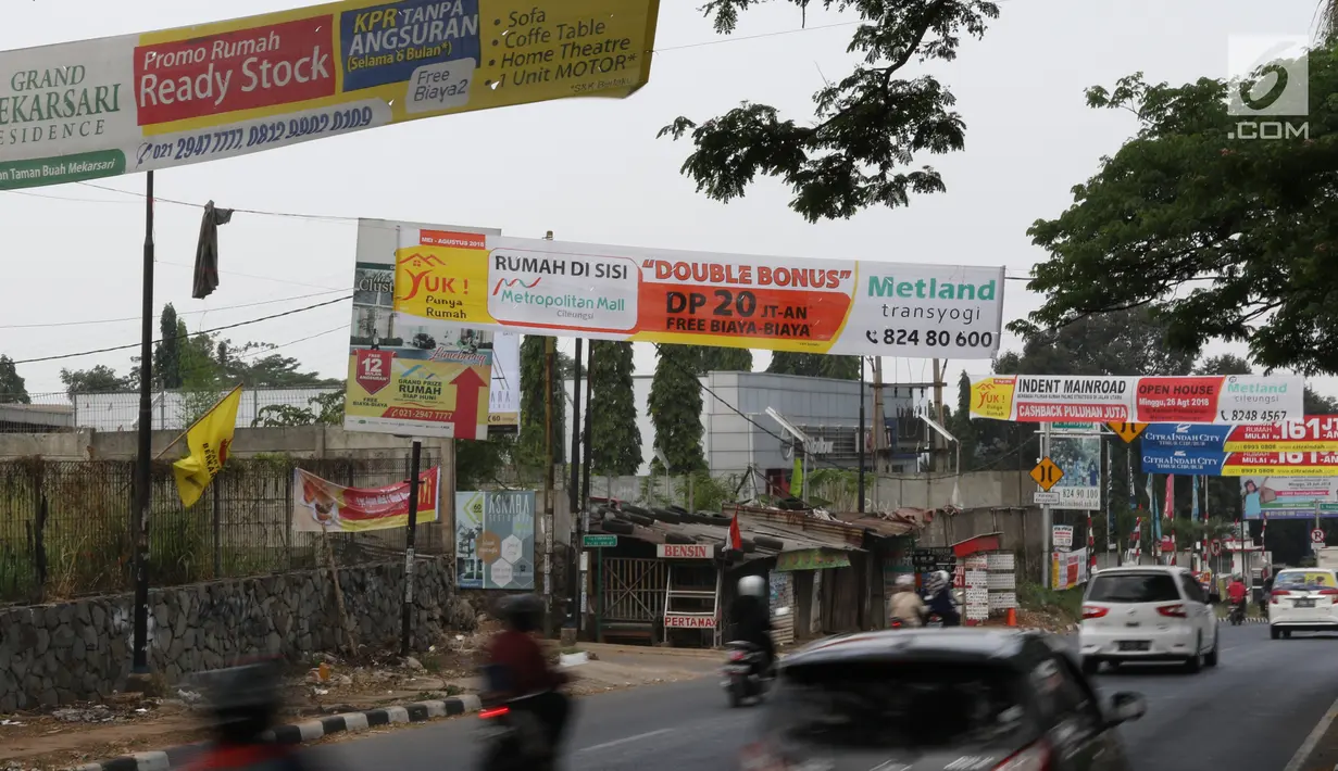 Kendaraan melintas di bawah spanduk iklan penjualan properti yang menghiasi kawasan Cibubur, Jakarta, Minggu (26/8). Tingginya kebutuhan akan hunian menyebabkan banyak pengembang memasang iklan tanpa memerhatikan estetika. (Liputan6.com/Immnuel Antonius)