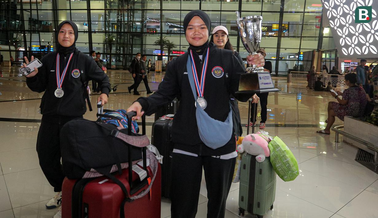 <p>Dua pemain Timnas voli putri Indonesia U-18, Agni Sakina Rahmi (kanan) dan Syifaal Fadila bersama rombongan tiba di Terminal 3 Bandara Soekarno Hatta, Tangerang, Jumat (14/6/2024) dalam acara penyambutan oleh pengurus PBVSI usai menempati peringkat kedua pada turnamen bola voli putri Princess Cup 2024. (Bola.com/Bagaskara Lazuardi)</p>