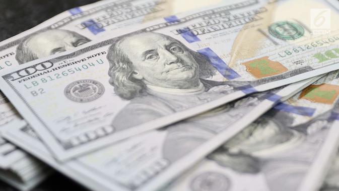 Petugas memperlihatkan uang pecahan dolar Amerika di salah satu gerai penukaran mata uang di Jakarta, Jumat (18/5). Pagi ini, nilai tukar rupiah melemah hingga sempat menyentuh ke Rp 14.130 per dolar Amerika Serikat (AS). (Liputan6.com/Immanuel Antonius)