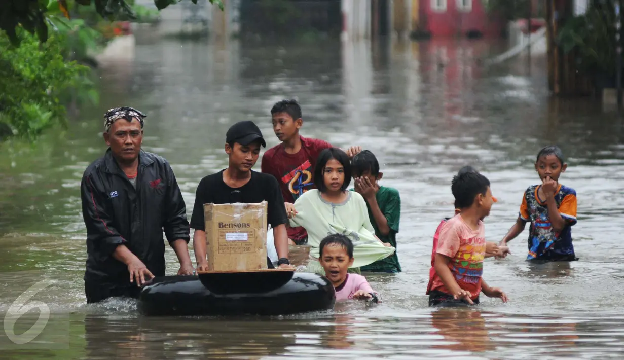 Warga melintasi banjir dibantu ban karet di perumahan Pondok Hijau Permai, Bekasi, Senin (20/2). Terdata, sedikitnya ada empat perumahan yang terendam banjir hingga ketinggian satu meter lebih. (Liputan6.com/Gempur M. Surya)