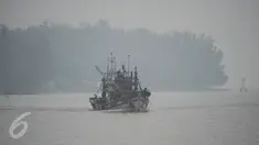 Nelayan berlayar dengan perahu di sungai Narathiwat yang diselimuti kabut asap, Thailand, Senin (5/10/2015). Kabut asap dari kebakaran hutan di Indonesia kini menyelimuti provinsi di wilayah selatan Thailand. (AFP PHOTO/Madaree TOHLALA)