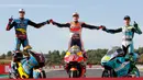 Pembalap MotoGP Marc Marquez (tengah) bersama pembalap Moto2 Alex Marquez (kiri) dan pembalap Moto3 Lorenzo Dalla Porta (kanan) berpose di depan Valencia Motorcycle Grand Prix, Spanyol, Minggu (17/11/2019). Ketiganya sukses merebut gelar juara dunia tahun 2019. (AP Photo/Alberto Saiz)