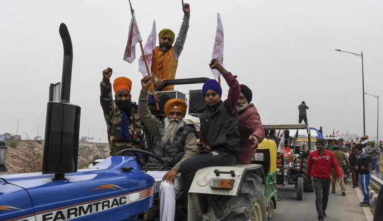 Para petani membawa traktor berpartisipasi dalam unjuk rasa di Jalan Tol Kundli – Manesar – Palwal (KMP) di Kundli di negara bagian Haryana (7/1/2021). Para petani berkumpul di perbatasan Ghazipur dan mengorganisir reli traktor untuk memenuhi permintaan mereka. (AFP/Prakash Singh)