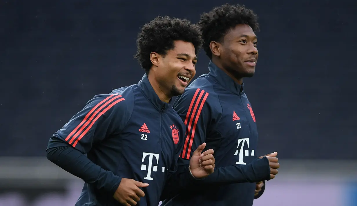 Gelandang Bayern Munchen, Serge Gnabry (kiri) dan bek David Alaba melakukan pemanasan saat sesi latihan tim di Tottenham Hotspur Stadium, London (30/9/2019). Munchen akan bertanding melawan tuan rumah Tottenham Hotspur pada grup B Liga Champions. (AFP Photo/Daniel Leal-Olivas)