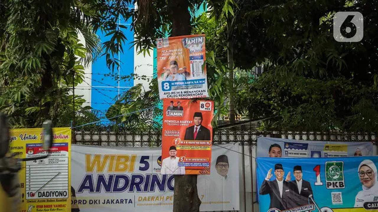 Sejumlah alat peraga kampanye (APK) terpasang pada pohon di kawasan Jakarta Selatan, Rabu (10/1/2024). Tak hanya bikin kumuh, maraknya pemasangan APK di pepohonan berpotensi merusak lingkungan hidup. Terlebih apabila pemasangan dilakukan menggunakan paku.