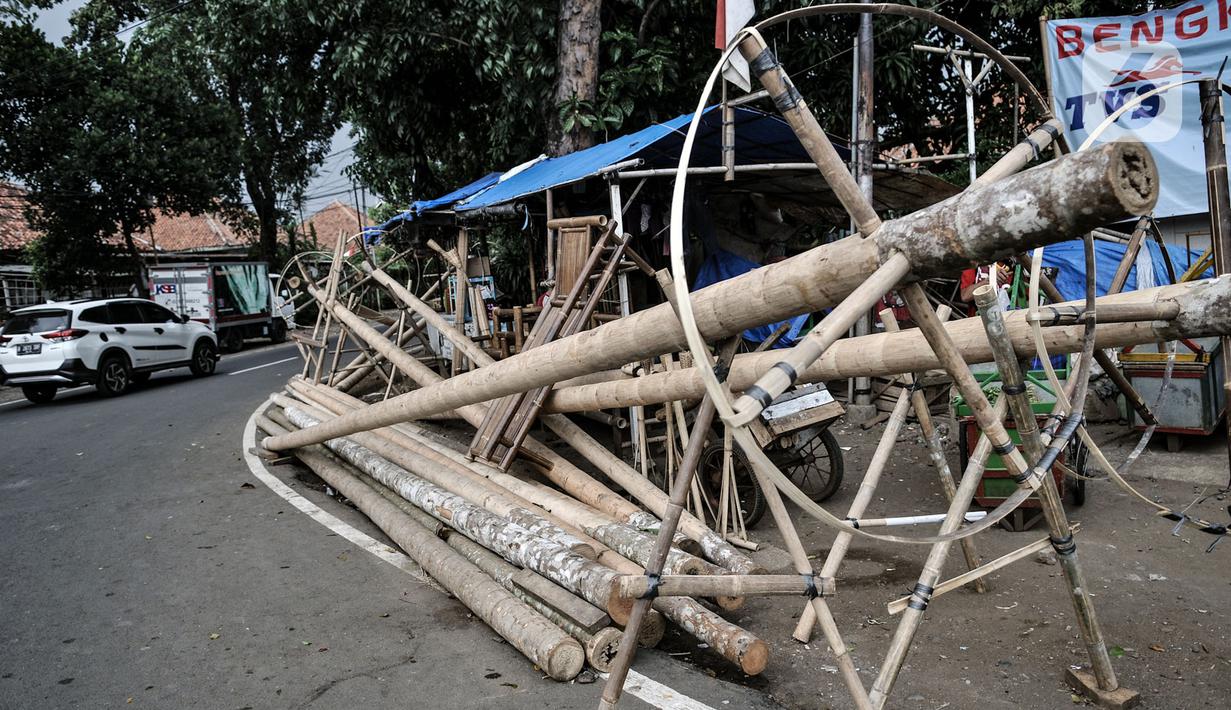 Kendaraan melintas di depan tumpukkan pohon pinang yang dijual di Jalan Manggarai Utara, Jakarta, Selasa (11/8/2020). Penjualan pohon pinang tahun ini menurun drastis dibandingkan tahun sebelumnya akibat pandemi Covid-19 yang menyebabkan larangan sejumlah perlombaan. (merdeka.com/Iqbal Nugroho)