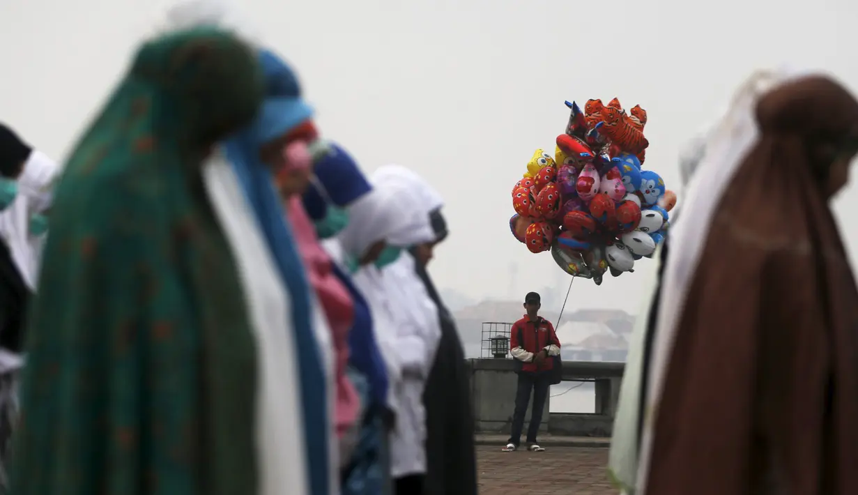 Sejumlah warga melakukan Salat Minta Hujan dekat Sungai Musi di Palembang, Minggu (20/9/2015). Mereka berharap Tuhan segera menurunkan hujan dan menghilangkan kabut asap yang melanda Sumatra dan Kalimantan. (Reuters/Beawiharta)