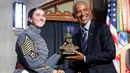 Mantan Presiden Amerika Serikat (AS), Barack Obama (kanan) menerima patung kadet dalam upacara penganugerahan Sylvanus Thayer Award 2024 dari Akademi Militer AS di West Point, New York, pada 19 September 2024. (KENA BETANCUR/AFP)