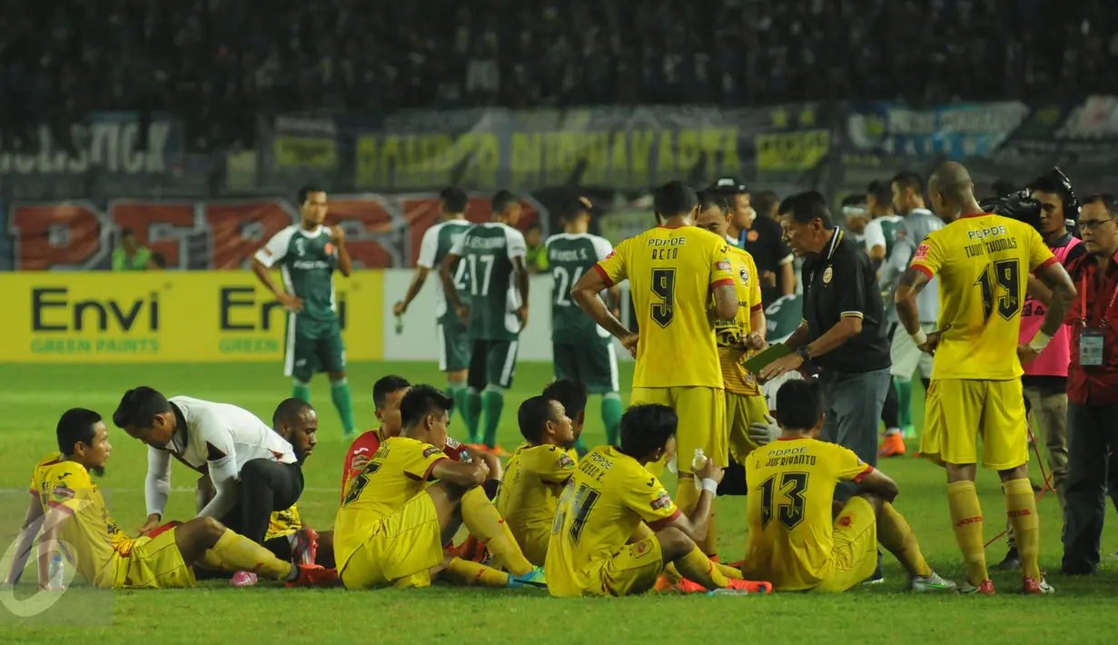 Pelatih Sriwijaya FC, Benny Dollo (kaos hitam) memberi arahan pada timnya saat jeda laga Turnamen Piala Bhayangkara di Stadion Si Jalak Harupat, Bandung, Minggu (20/3/2016). Sriwijaya FC unggul 2-1 atas PS TNI. (Liputan6.com/Helmi Fithriansyah)