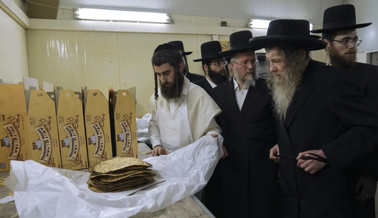 Yahudi Ultra-Ortodoks menyiapkan matzoh spesial di sebuah toko roti di Ashdod, Israel, 11 April 2022. Matzoh adalah roti tradisional tidak beragi yang dibuat untuk Paskah. (AP Photo/Tsafrir Abayov)