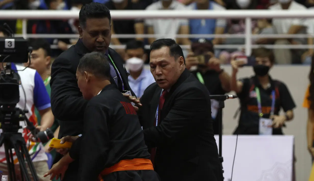 Pelatih Indonesia lainnya, Indro Catur Haryono (tengah) pun berusaha melerai dan menenangkan Benny Sumarsono yang juga menjabat sebagai Ketua Eksekutif Persekutuan Pencak Silat Antarabangsa (Persilat). (Bola.com/Ikhwan Yanuar)
