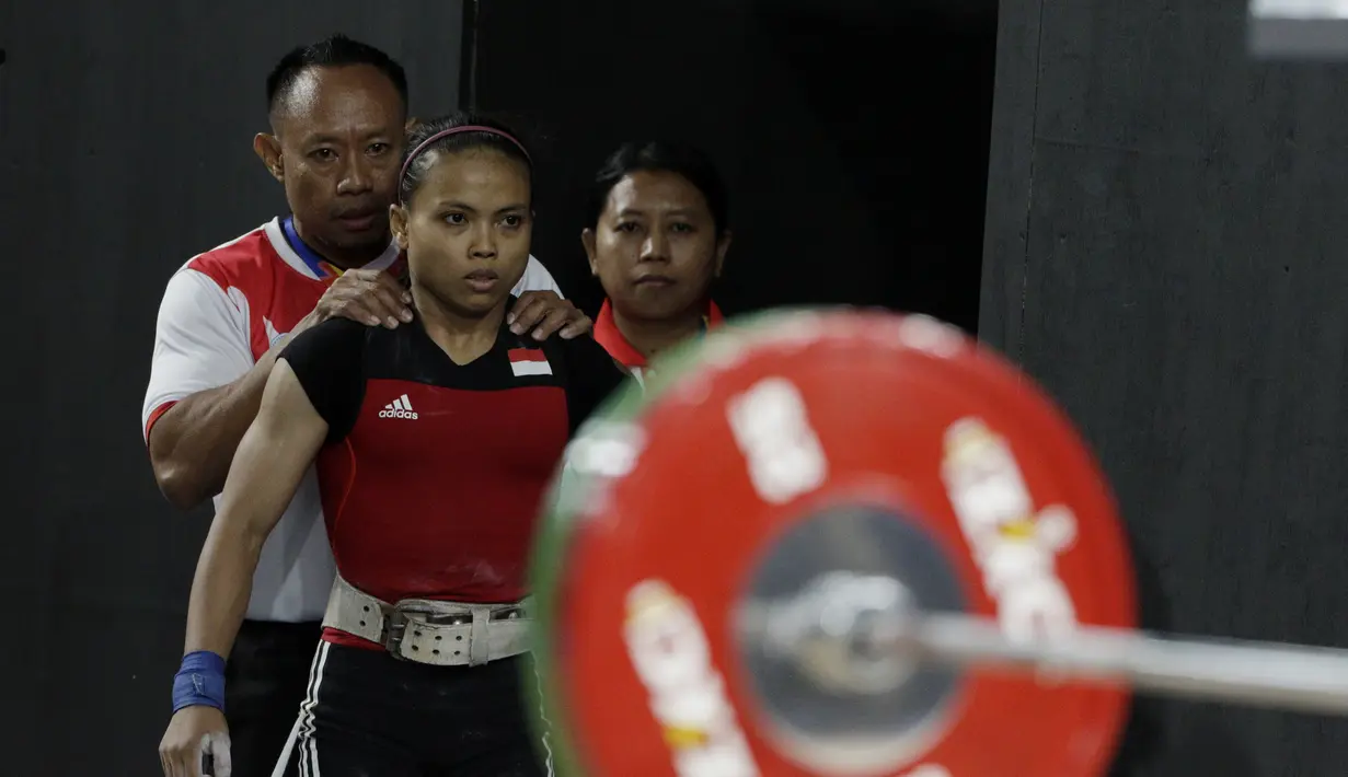 Lifter Lisa Setiawati bersiap melakukan angkatan pada SEA Games 2019 cabang angkat besi nomor 45 kg di Stadion Rizal Memorial, Manila, Minggu (1/12). Dirinya meraih perak dengan total angkatan 169 kg. (Bola.com/M Iqbal Ichsan)
