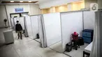 Petugas melintasi ruang isolasi mandiri pasien COVID-19 di Gelanggang Remaja Kecamatan Pademangan, Jakarta, Senin (28/9/2020). Sebanyak 30 bilik isolasi pasien Covid-19 disediakan dengan fasilitas tempat tidur, lemari, dan peralatan mandi. (Liputan6.com/Faizal Fanani)