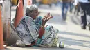 Seorang wanita saat mengemis di pinggir jalan di Hyderabad (10/11). Ivanka Trump akan menjadi pembicara pada KTT Kewirausahaan Global bersama Perdana Menteri India Narendra Modi. (AFP/Noah Seelam)