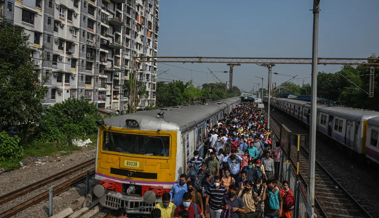 Komuter memadati peron kereta api di Kolkata, India, Senin (1/11/2021). Layanan kereta api kembali normal setelah menerapkan pembatasan yang diberlakukan sebelumnya untuk mengekang penyebaran corona Covid-19. (DIBYANGSHU SARKAR/AFP)