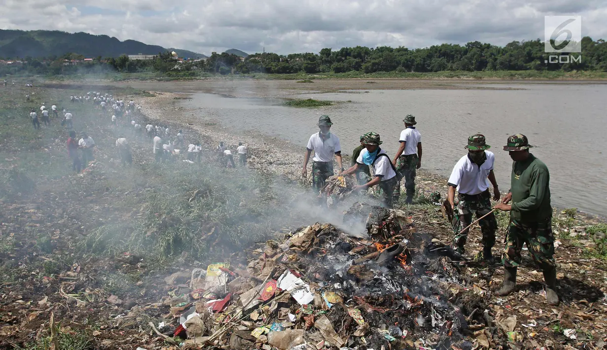 Personel TNI AL membakar sampah di sungai Citarum, Desa Warung Pulus, Bandung Barat, Jawa Barat, Minggu (17/12). Memperingati HUT TNI AL ke 72, melaksanakan operasi bakti TNI AL dengan menggelar acara "Bebersih Citarum". (Liputan6.com/Herman Zakharia)