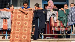 Badan Bantuan dan Pekerjaan PBB untuk Pengungsi Palestina (UNRWA) mengubah sekolah menjadi lokasi penampungan bagi para pengungsi Palestina di Khan Yunis, Jalur Gaza selatan pada 25 Oktober 2023. (MAHMUD HAMS/AFP)