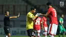 Kiper Persija, Andritany (tengah) keluar lapangan akibat cedera saat laga melawan Sriwijaya FC di lanjutan Liga 1 Indonesia di Stadion Wibawa Mukti, Cikarang Kab Bekasi, Jumat (16/6). Persija unggul 1-0. (Liputan6.com/Helmi Fithriansyah)