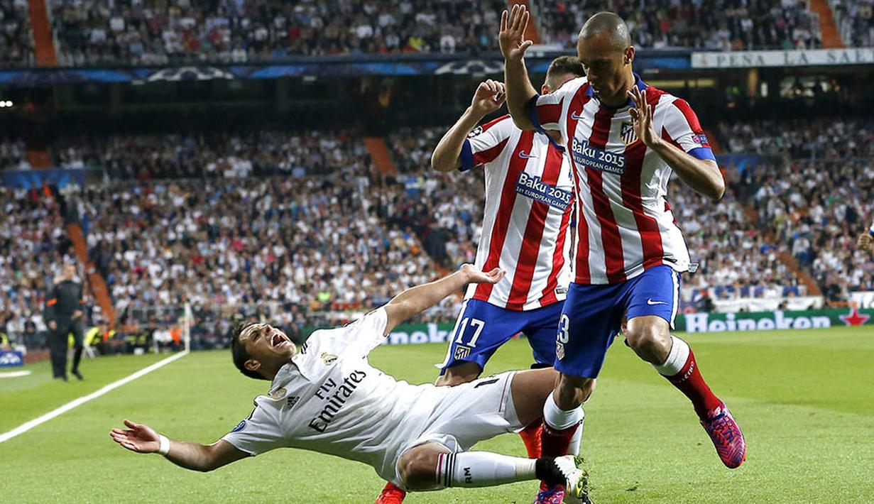 Penyerang Real Madrid, Chicharito, terjatuh didorong pemain Atletico Madrid, Joao Miranda pada laga perempat final Liga Champions di Stadion Santiago Bernabeu, Spanyol, Rabu (22/4/2015). (EPA/Juanjo Martin)