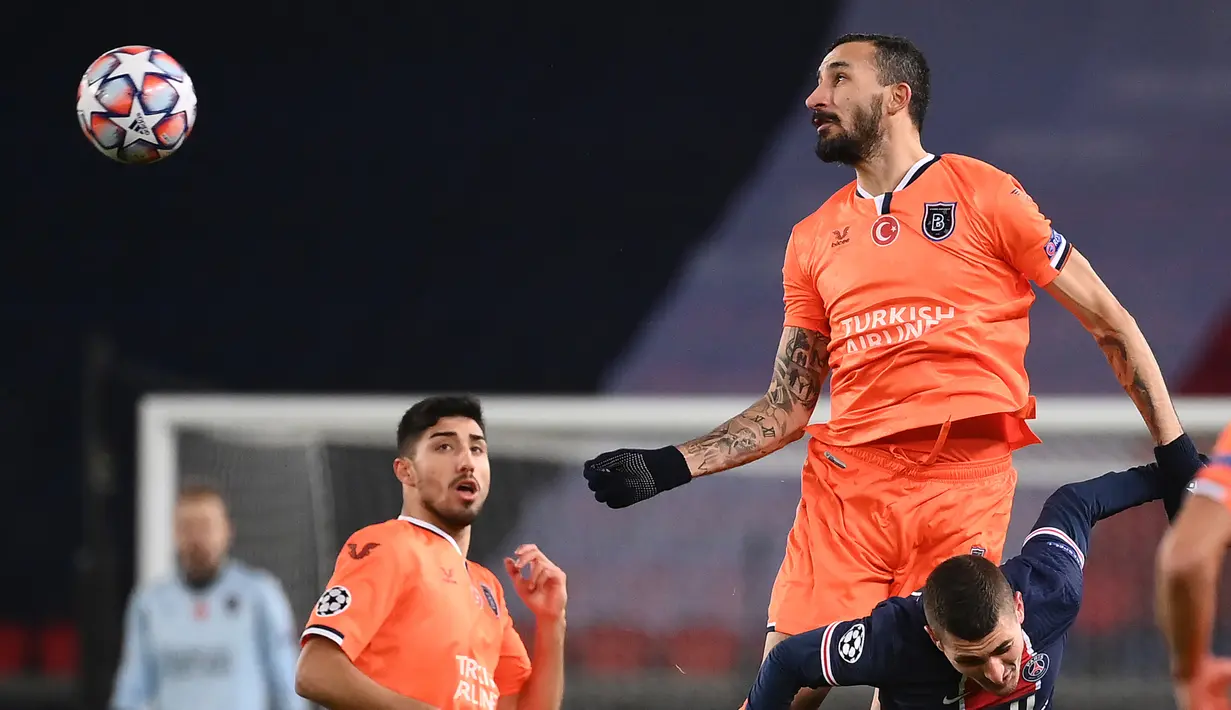 Gelandang Istanbul Basaksehir, Mehmet Topal (atas), menyundul bola di atas gelandang Paris Saint-Germain, Marco Verratti, dalam laga lanjutan Liga Champions 2020/21 Grup H di Parc des Princes Stadium , Paris, Rabu (9/12/2020). Basaksehir kalah 1-5 dari PSG. (AFP/Franck Fife)