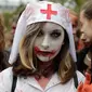 Seorang wanita mengenakan kostum suster bergaya zombie berpose saat mengikuti "Zombie Walk" di Paris, Prancis (7/10). (AFP Photo/Thomas Samson)