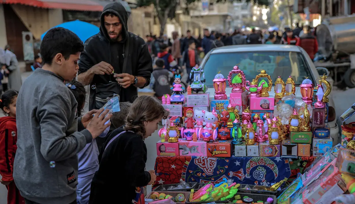 Anak-anak Palestina melihat mainan yang dipajang oleh seorang pedagang kaki lima di Kota Gaza pada 8 Maret 2024. (Foto: AFP)