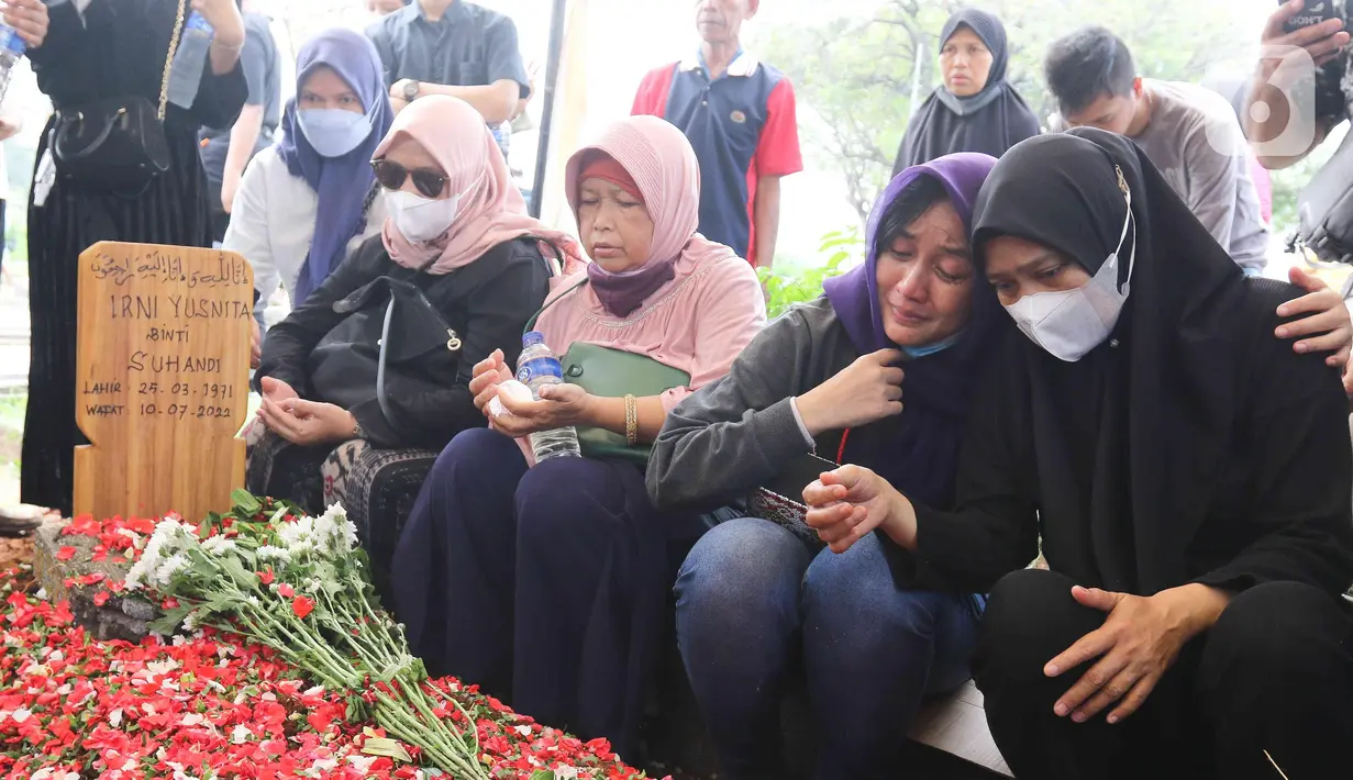 Keluarga dan kerabat berdoa di dekat makam pelawak Irni Yusnita  alias Rini S Bon Bon di TPU Kawi Kawi, Johar Baru, Jakarta, Senin (11/7/2022). Pelawak Rini S Bon Bon  meninggal dunia pada hari Minggu sore (10/7/2022), sebelum berpulang rini sempat mengidap  sakit diabetes. (Liputan6.com/Herman Zakharia)