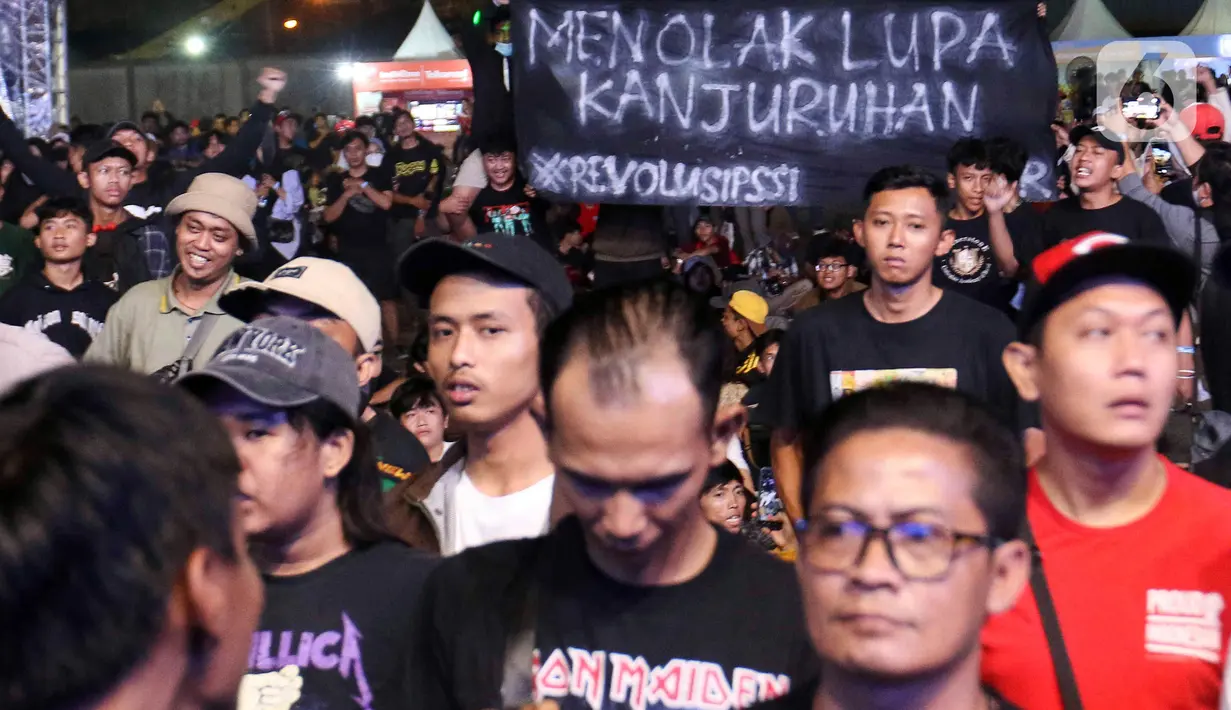 Spanduk bertuliskan "Menolak Lupa Kanjuruhan" terbentang saat acara doa bersama dan konser amal Salam Satu Jiwa di Bekasi, Jawa Barat, Minggu (8/1/2023). Konser ini merupakan bentuk dukungan dan solidaritas terhadap korban tragedi Kanjuruhan Malang. (Liputan6.com/Herman Zakharia)