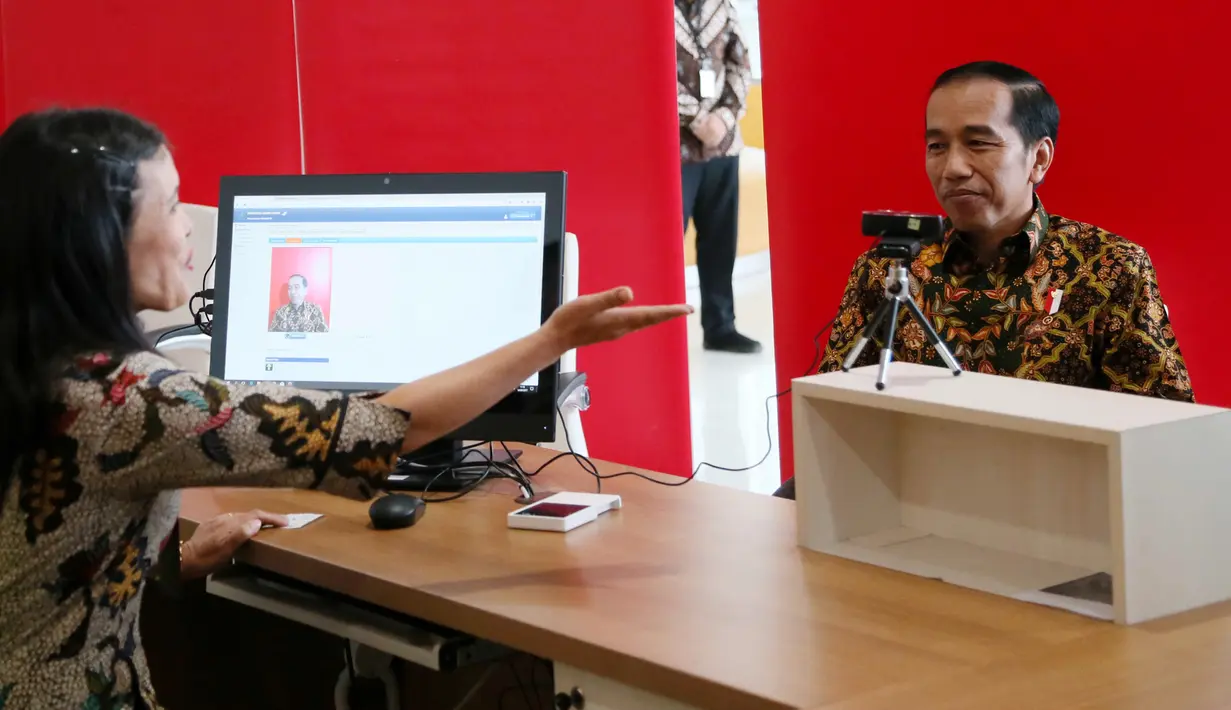 Presiden Jokowi dibantu petugas saat mendaftar menjadi anggota perpustakaan usai peresmian gedung baru Perpustakaan Nasional di Jakarta, Kamis (14/9). Jokowi berharap perpustakaan ini bisa meningkatkan minat baca masyarakat. (POOL/Kompas/Wisnu Widiantoro)