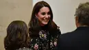 Kate Middleton mengobrol saat melihat pameran fotografi di National Portrait Gallery Exhibition, London, 28 Februari 2018. Kate tampil memukau dengan riasan makeup soft smokey eyes, lipstik nude dan rambutnya yang ditata bouncy curls. (AP/Frank Augstein)