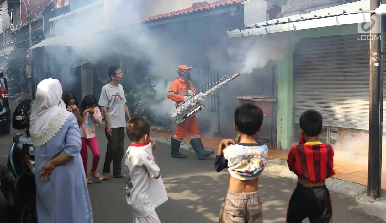 Warga melihat saat petugas melakukan pengasapan (fogging) di sebuah sekolah di kawasan Kebon Baru, Tebet, Jakarta, Kamis (28/2). Pengasapan dilakukan terkait adanya warga di kawasan itu yang terkena penyakit demam berdarah (Liputan6.com/Immanuel Antonius)