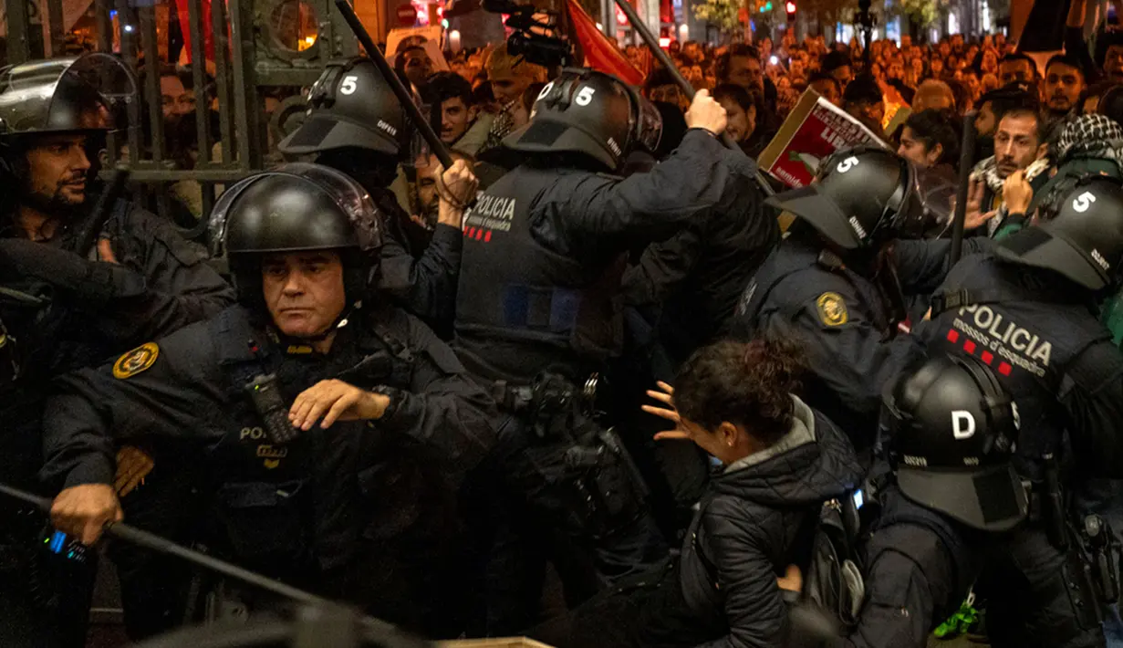 Polisi bentrok dengan demonstran pro-Palestina saat mereka mencoba masuk ke stasiun kereta di Barcelona, Spanyol, Sabtu (11/11/2023). (AP Photo/Emilio Morenatti)