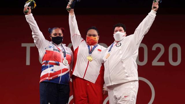 Li Wenwen mengangkat medali